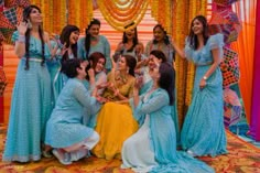 a group of people standing around each other in front of a decorated stage with decorations