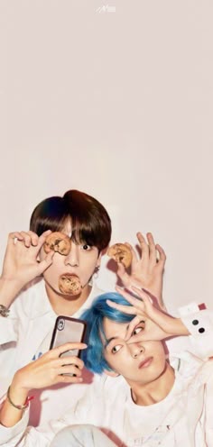 two young men with blue hair and cookies on their faces are posing for the camera