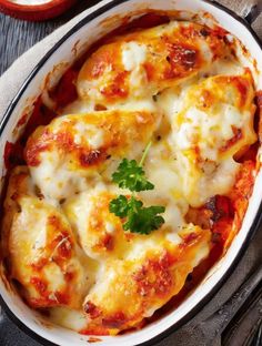 a casserole dish with meat and cheese on top, garnished with parsley