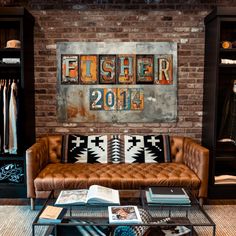 a living room filled with furniture and a brick wall above it is a sign that says fisher 2011