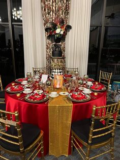 a table set with red and gold place settings