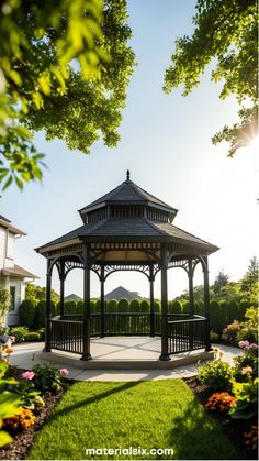 A black gazebo in a sunny garden, surrounded by flowers and greenery.