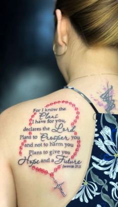 the back of a woman's shoulder with a cross and heart tattoo on it