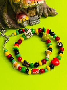 This hippie aesthetic necklace is Rastafarian themed and it's all made by me with chunky polymer clay tube  beads size 9mmx18mm. Spacers are 4mm-6mm Czech glass seed beads. other Spacer beads are also made from glass and are 8mm with glass rondelle beads in an assortment of colors. The size is roughly 16 1/2 inches and with the extended chain it is 19 inches. The closure is a silver lobster claw and has wire guards at each end for extra protection. This bead has Peruvian ceramic beads and the ru Hippie Style Large Beads For Gift, Hippie Style Large Beads For Gifts, Hippie Style Large Beads As Gift, Hippie Style Large Beads Gift, Hippie Style Wooden Beads Gift, Casual Handmade Heishi Beads Necklace, Adjustable Festival Necklace With Letter Beads, Festival Adjustable Necklace With Letter Beads, Bohemian Adjustable Necklace With Letter Beads