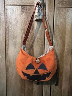 "This pumpkin bag is sure to conjure up the Halloween spirit in every outfit it's added to. Wear it facing out for a jack-o-lantern styled night or facing in for a less Halloween-ish and more fall-ish look! Handmade crossbody bag. Rust orange upholstery fabric handbag with adjustable strap. Strap measures 24\" to 46\" and can be worn as a crossbody bag or shoulder purse. Beige upholstery fabric interior with 6 inside pockets. Constructed with orange corduroy outer. Bag measures: 16\" across x 12 Fall Hobo Bag With Adjustable Strap, Orange Fall Bag With Adjustable Strap, Orange Bag With Adjustable Strap For Fall, Fall Orange Crossbody Bag, Halloween Shoulder Bag For Daily Use, Halloween Shoulder Bag Gift, Halloween Satchel Shoulder Bag With Adjustable Strap, Halloween Gift Crossbody Bag, Halloween Gift Shoulder Bag