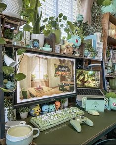 there is a computer on the desk with plants