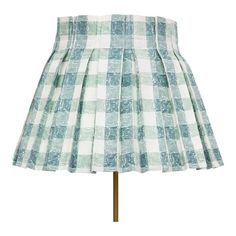 a green and white checkered skirt on a mannequin stand with a wooden base