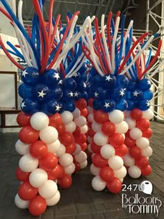 red, white and blue balloons are arranged in the shape of an american flag on display