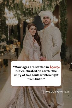 a man and woman standing next to each other in front of a chandelier