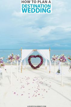 a wedding ceremony on the beach with flowers in the sand and an archway to the ocean