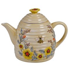 a ceramic teapot with yellow flowers and a bee on it