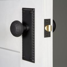 an open door with a black handle and brass knob on the front side of it