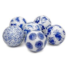 six blue and white ceramic balls on a white surface with floral designs in the middle