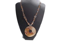 This necklace measures 16 inches long but it has an adjustment chain of 4 inches for added length. The beads are brown wood and copper-colored metal beads. The abalone (mother-of-pearl pendant measures 2 inches long and wide. Brown Polished Bead Round Necklaces, Brown Polished Beads Round Necklace, Brown Necklaces With Polished Beads, Adjustable Round Brown Beaded Necklace, Adjustable Brown Beaded Round Necklace, Adjustable Brown Round Beaded Necklace, Adjustable Brown Beaded Necklace, Brown Shell Necklace With Round Beads For Gift, Unique Brown Beaded Pendant Necklace