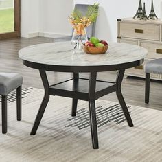 a dining table with two chairs and a bowl of fruit on top of the table