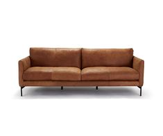 a brown leather couch sitting on top of a white floor next to a black metal frame