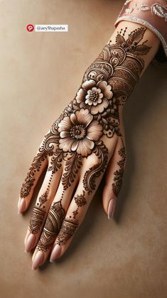 a woman's hand with henna tattoos on it