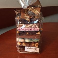 a stack of assorted desserts wrapped in cellophane on top of a wooden table