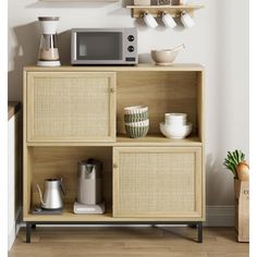 a microwave sitting on top of a wooden cabinet next to bowls and coffee pots