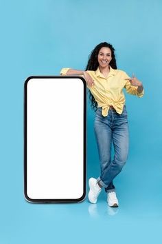 a woman is posing with her arms out and holding a large white board in front of her