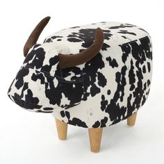 a toy cow with horns on it's head is sitting in front of a white background