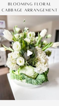 an arrangement of flowers in a bowl on a table with the words blooming floral cabbage arrangement