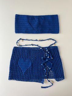 a crocheted blue skirt and headband on a white surface with beads attached to it