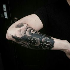 a person with a black and white tattoo on their arm