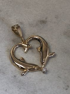 "14kt Yellow Gold Lady's Kissing Dolphin Pendant with a full cut round brilliant diamond accent in center. This Pendant is 1\" in length, 3/4\" wide, has a flat back and has a shiny bright plain polished finish. The total weight is 2.1 grams. This item would Retail for $388.00" Yellow Gold Heart Pendant With Prong Setting, Yellow Gold Heart Pendant Jewelry With Prong Setting, 14k Gold Heart Cut Diamond Accented Jewelry, 14k Gold Heart Cut Jewelry With Diamond Accents, 14k Gold Jewelry With Heart Cut Diamond Accents, Heart Cut Diamond Accent Jewelry In 14k Gold, Heart Cut Diamond Jewelry With Polished Finish, Gold Diamond Jewelry Stamped 14k, Valentine's Day 14k Gold Jewelry With Single Cut Diamonds