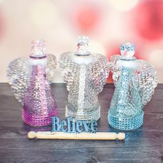 three glass angel figurines sitting on top of a wooden table