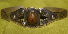 Harvey Era. Old Pawn Navajo Cuff. Hand wrought stampings & repousse work in sterling silver.  Focal Point -  carved Petrified Wood/Quartz - Golden walnut brown. Unmarked. Unsigned. Seasoned Navajo Silversmith. c1950. Very good condition.  SIZE:  6" plus 1" opening WIDTH:  3/4" WEIGHT:  17.1 Grams FREE WORLDWIDE SHIPPING No Returns. No Refunds. Proceeds support the animals I adopt who are rescued by Volunteer Vets from native reserves for 20+yrs. No more Chains, cold, hunger or further misery. All are spayed/neutered to prevent over-population. Could not do this without your help. TY FOR THE LOVE OF ANIMALS 'The greatness of a nation and their moral progress can be judged by the way it's animals are treated.'  -Mahatma Gandhi Vintage Stamped 925 Sterling Silver Cuff Bracelet, Antique Stamped Sterling Silver Cuff Bracelet, Vintage Collectible Cuff Bracelet With Polished Finish, Vintage Silver Cuff Bracelet With Concho, Vintage Silver Bracelets With Concho, Vintage Oval Cuff Bracelet With Polished Finish, Vintage Sterling Silver Concho Cuff Bracelet, Vintage Concho Cuff Bracelet For Gift, Vintage Concho Cuff Bracelet Gift