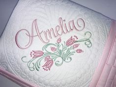 an embroidered pillow with the word amelia written in cursive font on it