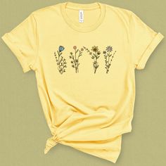 You'll channel your inner wild heart in this wildflower graphic tee, and feel warm sunny vibes. DETAILS This super soft and comfortable graphic t-shirt is made of 49% to 100% combed and ring-spun cotton. Check the size card for specific fabrications per color. I picked this t-shirt for its clean crew neckline, and contoured classic cut, that shoes our shape while not being too tight . I believe in social and environment responsibility. This t-shirt is fairly produced, uses eco friendly inks and Botanical Printed Relaxed Fit T-shirt, Botanical Plants Print Relaxed Fit T-shirt, Botanical Plants Print T-shirt With Relaxed Fit, Botanical Relax Fit T-shirt With Plant Print, Botanical Relaxed Fit T-shirt With Plant Print, Yellow Plants Print Short Sleeve T-shirt, Yellow Short Sleeve T-shirt With Plant Print, Spring Yellow T-shirt With Screen Print, Yellow Screen Print T-shirt For Spring