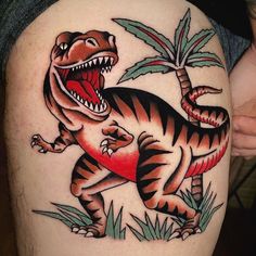 an image of a dinosaur tattoo on the thigh