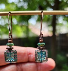 The centerpiece for these stunning boho earrings is a transparent turquoise tile bead with a gorgeous starburst.  Another petite pair of earrings! Simply gorgeous Czech glass! Love the look! These unique beauties are just under two inches in length, including the copper hooks.  The turquoise Czech glass square beads are accented with a stack of copper beads interspersed with Turquoise disc beads.  These square starburst beads are some of my favorite beads because of the richness of the color, their transparency and the design.  One of a kind design. Lightweight! Handmade. Smoke free artist studio. Turquoise Tile, Tile Earrings, Starburst Earrings, Square Bead, Square Earrings, I Love Jewelry, Earrings Boho, Boho Beach, Copper Earrings