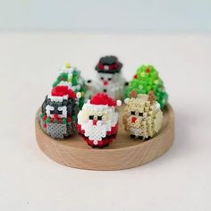 a group of small knitted animals sitting on top of a wooden plate next to each other