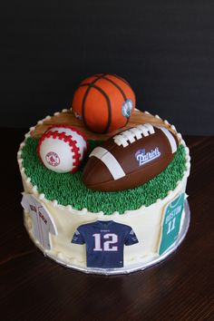 a cake decorated with footballs and other sports items on top of a wooden table