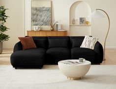 a living room with a black couch and white rug