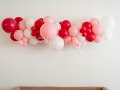 the balloon wall is decorated with pink, white and red balloons