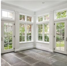 an empty room with double doors and windows