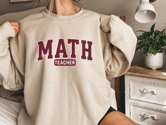 Our Math Teacher sweatshirt is perfect for classroom wear or casual days out. This sweatshirt is designed with comfort and passion for teaching in mind. Whether you're solving equations or inspiring young minds, this is the perfect addition to your wardrobe! When it comes to sizing, this shirt is a UNISEX sweatshirt, it does run true to size however please refer to the sizing chart to choose which sweatshirt would fit best. : 50% cotton, 50% polyester : Heather Sport colors - 60% polyester, 40% cotton .: Medium-heavy fabric  .: Loose fit .: Tear-away label .: Runs true to size Phillies Shirt, Superhero Shirt, Hoodie Streetwear, Crewneck Style, Edward Cullen, Men's Coats & Jackets, Women Shirts Blouse, Unisex Tshirt, Casual Pullover