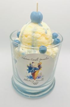 an ice cream sundae with blue and white toppings in a clear glass container