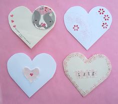 four heart shaped greeting cards on a pink background