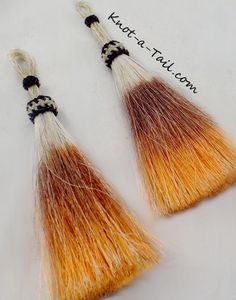 two orange and white tassels with black beads