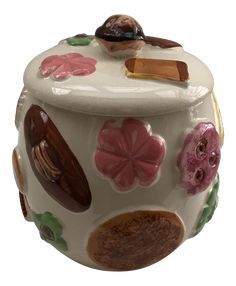 a ceramic jar with flowers and leaves painted on it