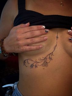 a woman's stomach with tattoos on it and her hands holding the side of her body