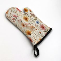 an oven mitt with flowers on it sitting on top of a white countertop