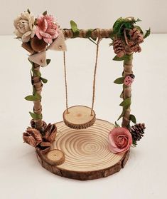 a wooden swing decorated with flowers and pine cones