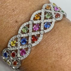 "Stunning Rainbow Sapphire Bracelet White Gold.  Beautiful colors on these fancy sapphires.  You can wear this happy, good luck bracelet with anything.  Excellent craftsmanship, all stones set nice and smooth.  These natural sapphires are vibrant and full of life.  Measures about 17.2mm width.  Bracelet feels solid and lays perfectly on the wrist.  One only bracelet for a special lady!  This bracelet has the wow factor and is an heirloom piece.  Bracelet measures 7\" in length.   Genuine earth mined fancy color sapphires  Total weight: 16.18 carats Vibrant colors  Genuine earth mined round brilliant cut diamonds total weight: 4.30 carats  Clarity: SI/I Color: F Solid 18K White Gold 38 grams  Comes with gift box * We have been in the wholesale Jewelry business for over 30 years serving the Sapphire Bangle, Fancy Sapphire, Good Luck Bracelet, Rainbow Sapphires, Sapphire Bracelet, Wedding Jewelry Bracelets, Natural Sapphire, Jewelry Business, Wedding Bracelet