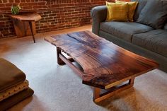 a living room with a couch, coffee table and brick wall in the back ground